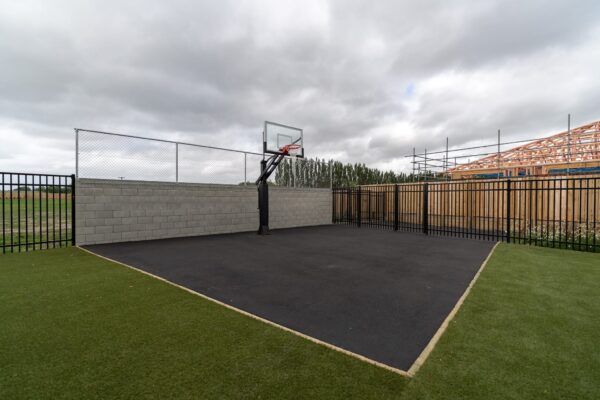 image of metal chainlink fencing behind basketball hoop, and black metal fences installed by Axiom Built at Pītau-Allenvale School in Belfast, Christchurch