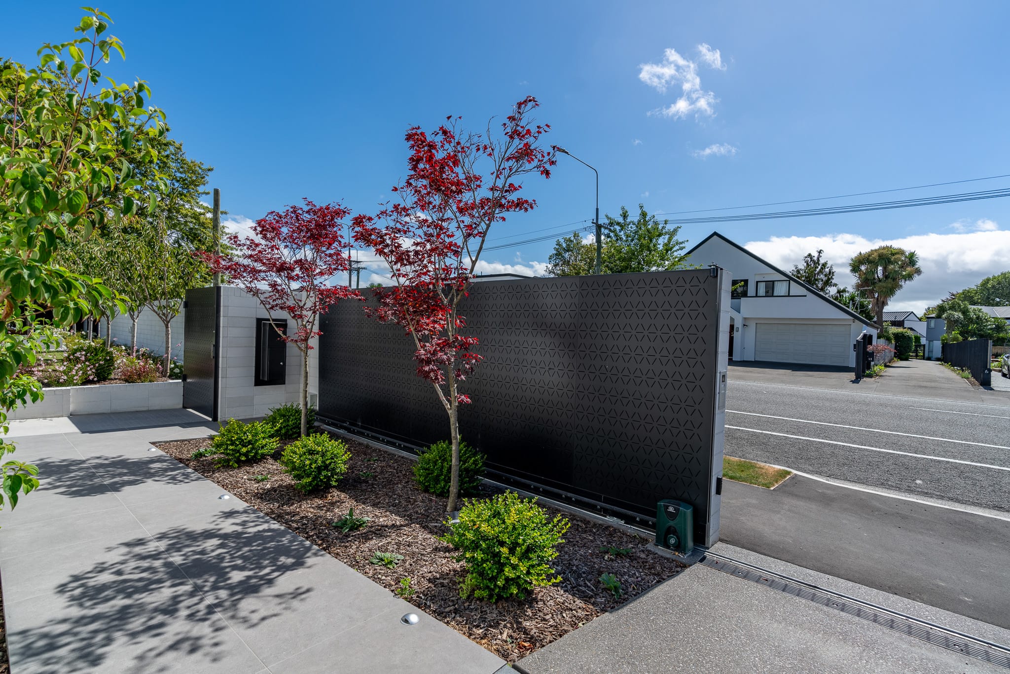 custom black metal electric privacy gate designed and installed at a private property by Axiom Built in Christchurch